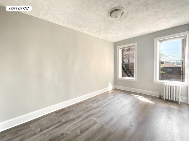 24-75 38th St Unit C9, New York City, NY 11103 - spare room with radiator, a textured ceiling, and dark wood finished floors