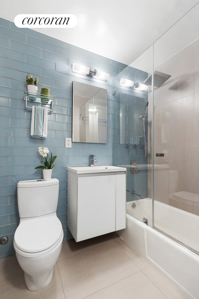 115 E 9th St Unit 6M, New York City, NY 10003 - bathroom featuring toilet, tile patterned flooring, vanity, and enclosed tub / shower combo