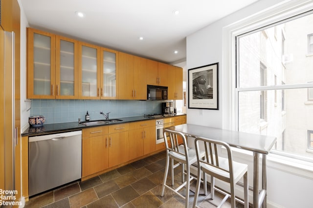 54 Riverside Dr Unit 9D, New York City, NY 10024 - kitchen with stainless steel appliances, a sink, decorative backsplash, glass insert cabinets, and dark countertops