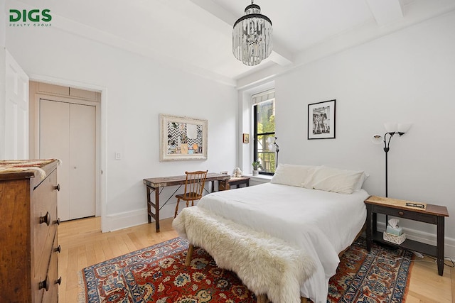 135 W 79th St Unit 1D, New York City, NY 10024 - bedroom featuring light wood-style floors, a chandelier, and beamed ceiling