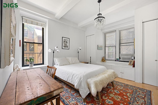 135 W 79th St Unit 1D, New York City, NY 10024 - bedroom featuring beamed ceiling, a chandelier, multiple windows, light wood-style flooring, and multiple closets