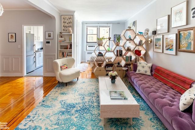 300 W 72nd St Unit 6E, New York City, NY 10023 - living room featuring crown molding, light wood-style flooring, and a wainscoted wall