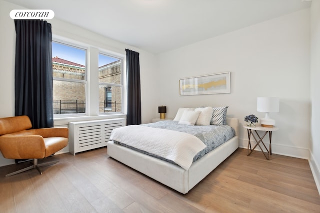 148-09 Northern Blvd Unit 4M, New York City, NY 11354 - bedroom with light wood-style flooring, radiator heating unit, and baseboards