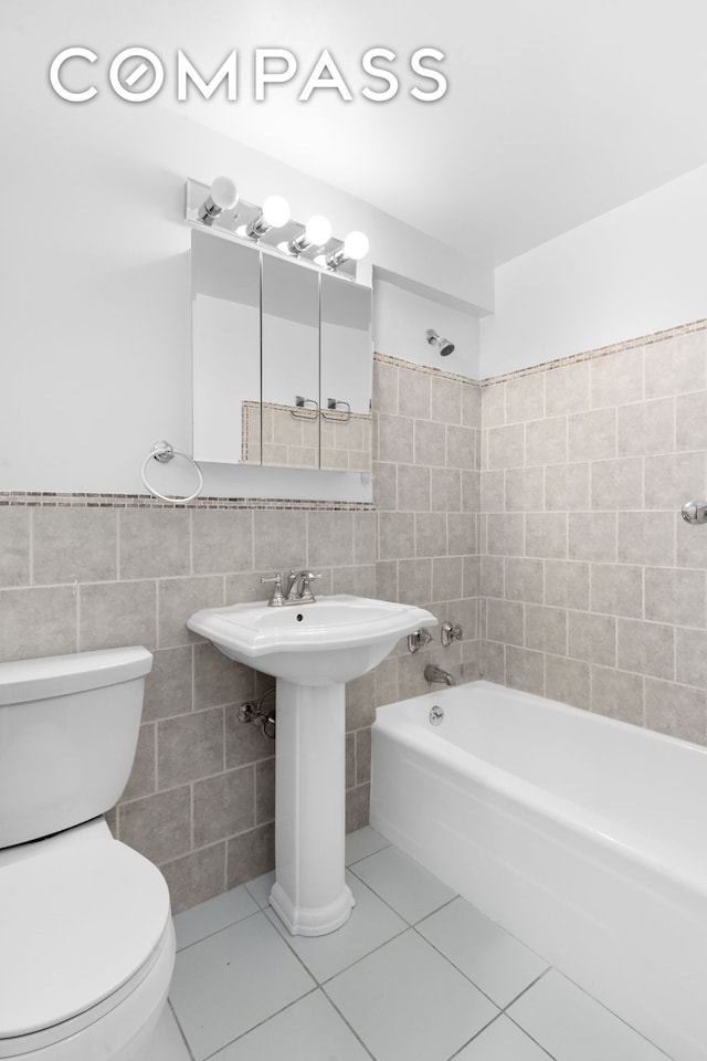 101 W 12th St Unit 3Z, New York City, NY 10011 - full bathroom with tile walls, toilet,  shower combination, tile patterned floors, and a sink