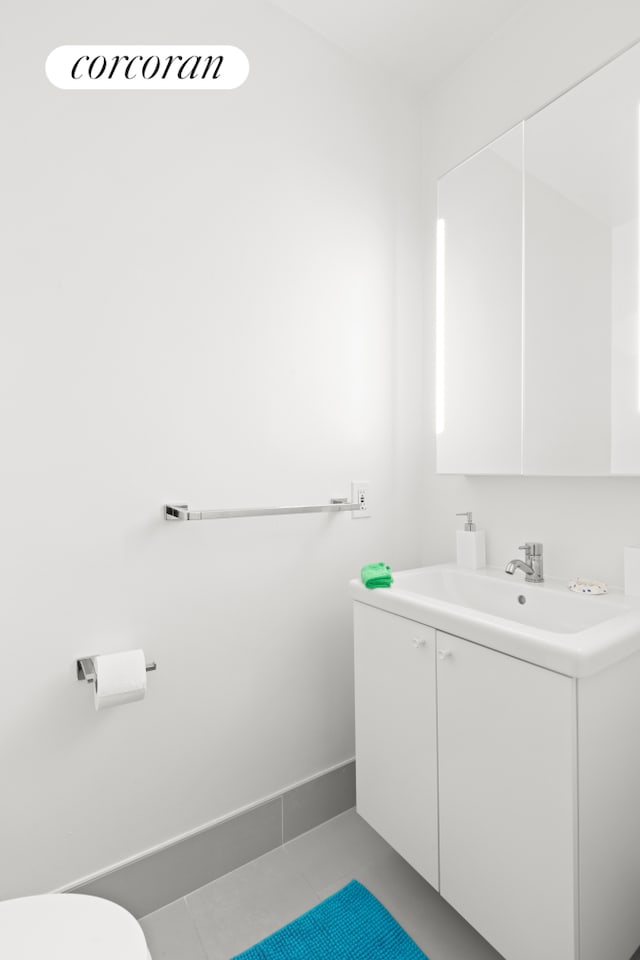 250 S End Ave Unit 7E, New York City, NY 10280 - half bath with vanity, tile patterned floors, toilet, and baseboards