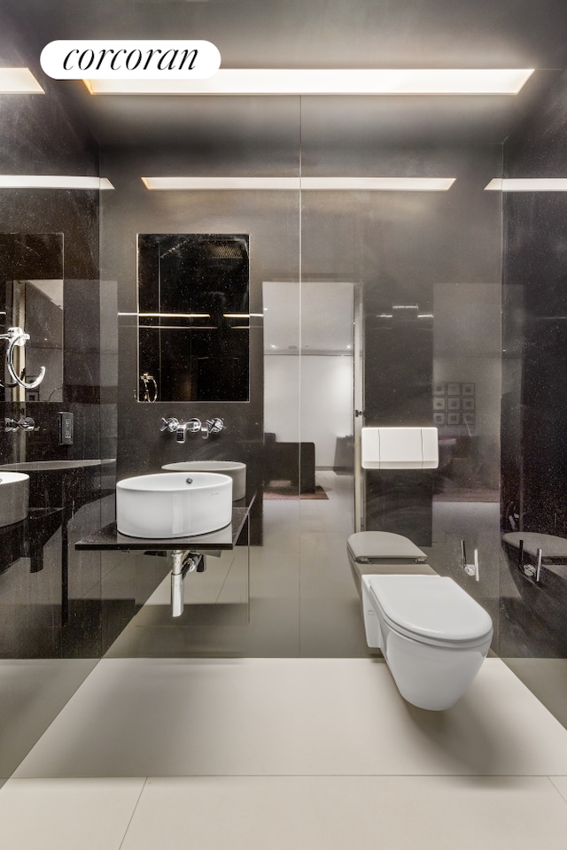 145 6th Ave Unit 5C, New York City, NY 10013 - bathroom with tile walls, toilet, and a sink