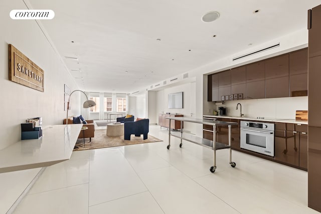 145 6th Ave Unit 5C, New York City, NY 10013 - kitchen featuring oven, modern cabinets, open floor plan, light countertops, and light tile patterned floors