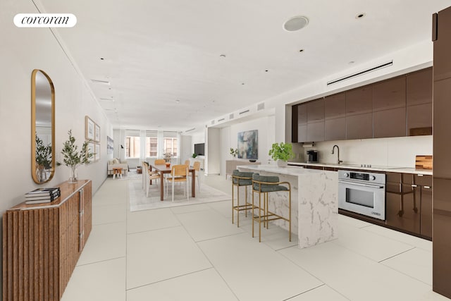 145 6th Ave Unit 5C, New York City, NY 10013 - kitchen with oven, modern cabinets, a kitchen bar, open floor plan, and a sink