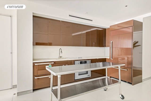 145 6th Ave Unit 5C, New York City, NY 10013 - kitchen featuring a sink, modern cabinets, oven, light countertops, and paneled refrigerator