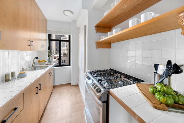 25 W 54th St Unit 8H, New York City, NY 10019 - kitchen with stainless steel range with gas cooktop, tile countertops, a sink, open shelves, and backsplash