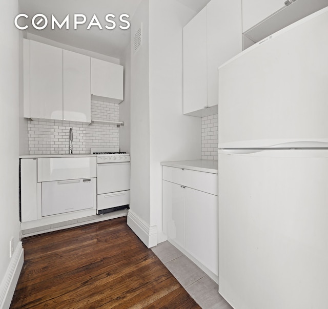 10 Bethune St Unit 2B, New York City, NY 10014 - kitchen featuring white appliances, tasteful backsplash, dark wood-type flooring, and light countertops
