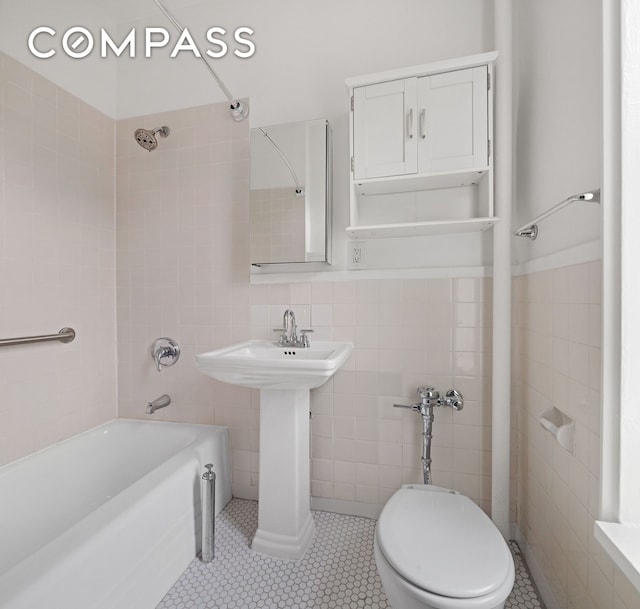10 Bethune St Unit 2B, New York City, NY 10014 - bathroom featuring tile walls,  shower combination, tile patterned flooring, toilet, and a sink