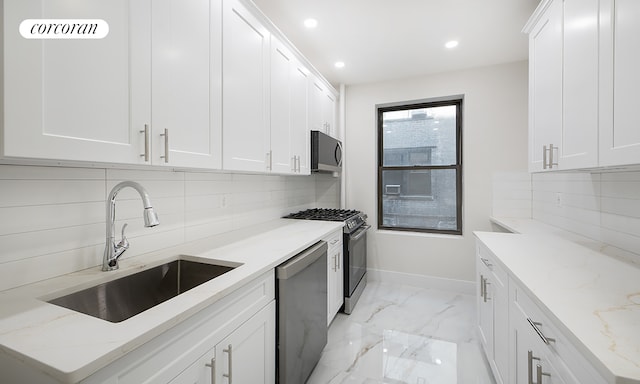 325 E 80th St Unit 1F, New York City, NY 10075 - kitchen featuring a sink, appliances with stainless steel finishes, baseboards, backsplash, and white cabinets