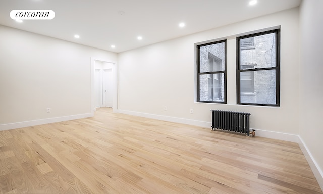 325 E 80th St Unit 1F, New York City, NY 10075 - spare room with radiator heating unit, light wood-type flooring, baseboards, and recessed lighting