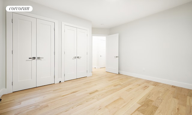 325 E 80th St Unit 1F, New York City, NY 10075 - unfurnished bedroom featuring light wood-style floors, baseboards, and multiple closets