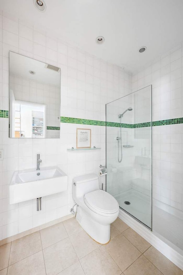 204 W Houston St Unit 4A/5A, New York City, NY 10014 - bathroom featuring tile walls, toilet, a tile shower, and tile patterned floors