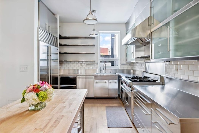 204 W Houston St Unit 4A/5A, New York City, NY 10014 - kitchen featuring stainless steel counters, premium appliances, a sink, and decorative backsplash