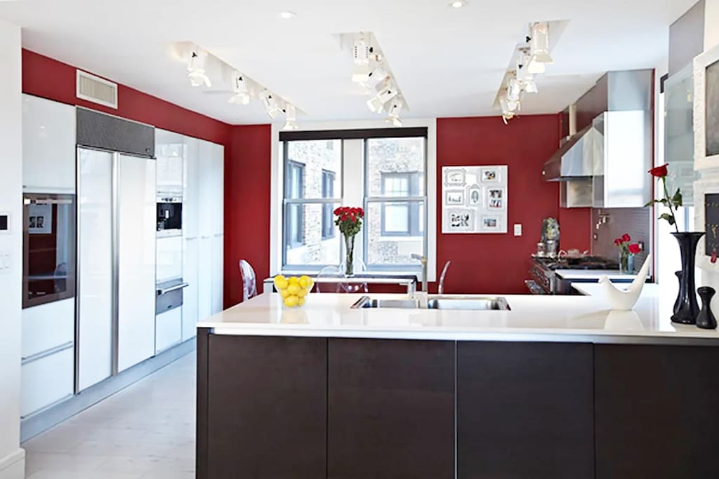 27 W 72nd St Unit 1410, New York City, NY 10023 - kitchen with track lighting, a sink, a peninsula, under cabinet range hood, and a warming drawer
