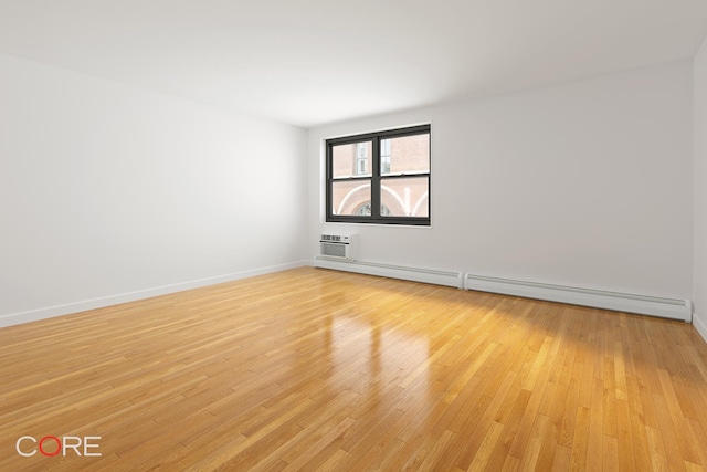 638 Washington St Unit 2B, New York City, NY 10014 - spare room with a baseboard heating unit, light wood-style flooring, and baseboards