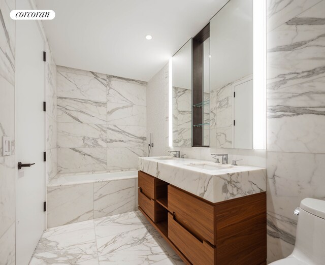 30 Riverside Blvd Unit 20C, New York City, NY 10069 - bathroom featuring double vanity, a tub with marble appearance, marble tiled floors, toilet, and tile walls