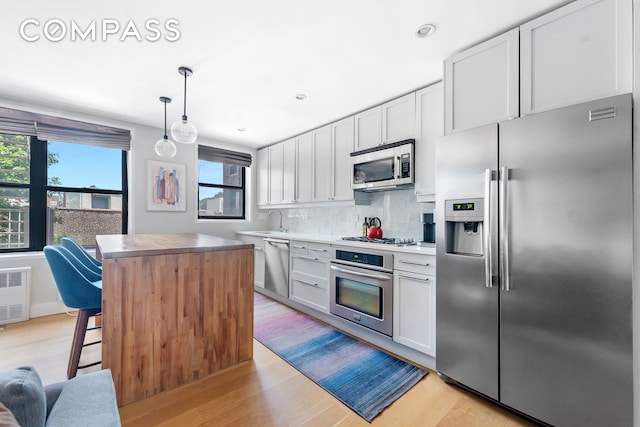 185 Prospect Park SW Unit 609, New York City, NY 11218 - kitchen featuring stainless steel appliances, tasteful backsplash, light wood finished floors, a kitchen island, and a sink