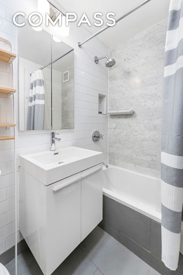 185 Prospect Park SW Unit 609, New York City, NY 11218 - full bathroom with tiled shower / bath combo, vanity, tile walls, and tile patterned flooring