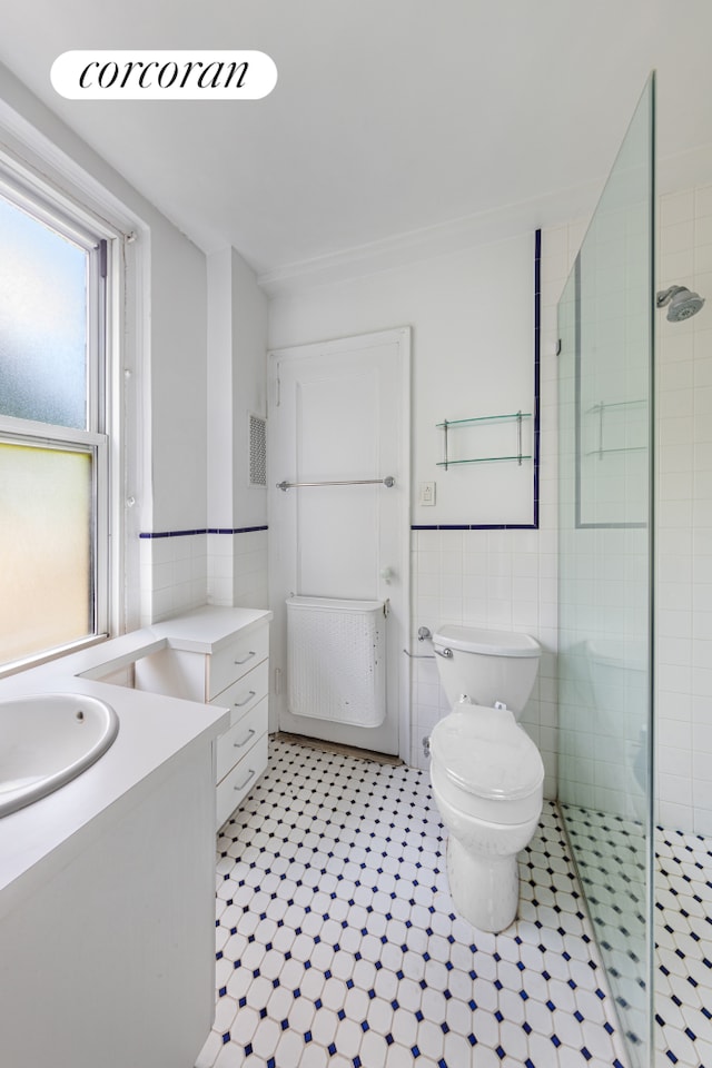 114 E 90th St Unit 5B, New York City, NY 10128 - full bath featuring tile walls, vanity, a shower stall, and wainscoting
