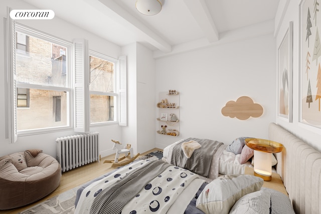 114 E 90th St Unit 5B, New York City, NY 10128 - bedroom with radiator heating unit, beam ceiling, multiple windows, and wood finished floors