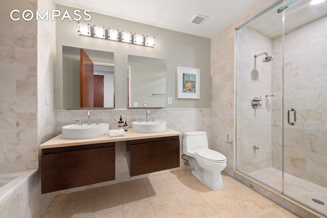 50 W 15th St Unit 2D, New York City, NY 10011 - bathroom featuring tile walls, a stall shower, double vanity, toilet, and a bath