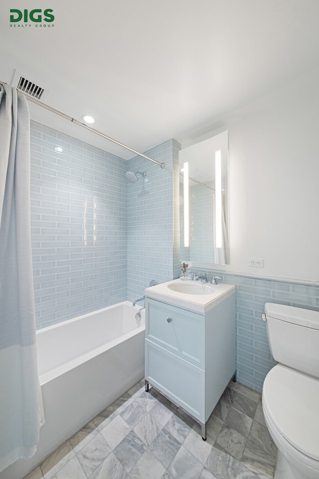 389 E 89th St Unit 27A, New York City, NY 10128 - bathroom with tile walls, shower / bath combo, vanity, and a wainscoted wall