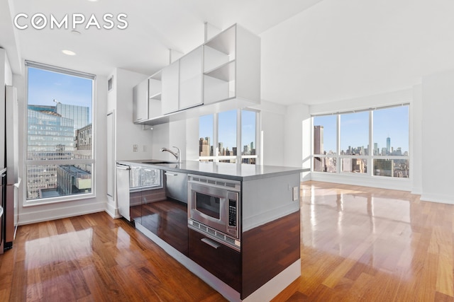 350 W 42nd St Unit 48E, New York City, NY 10036 - kitchen featuring a view of skyline, open shelves, appliances with stainless steel finishes, modern cabinets, and white cabinets