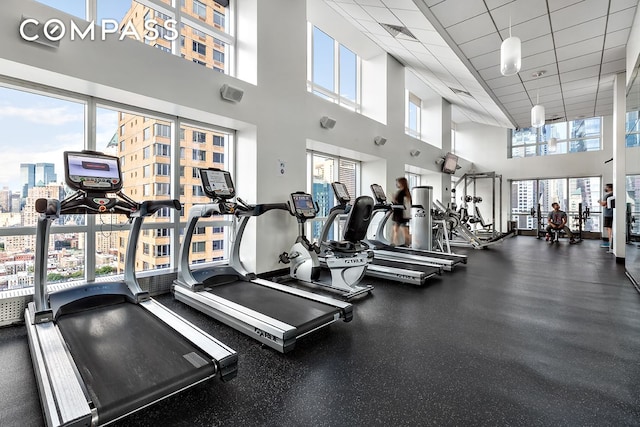 350 W 42nd St Unit 48E, New York City, NY 10036 - workout area featuring a towering ceiling, a view of city, and a drop ceiling