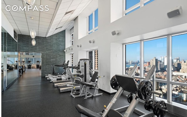 350 W 42nd St Unit 48E, New York City, NY 10036 - workout area with a towering ceiling, healthy amount of natural light, a view of city, and a drop ceiling