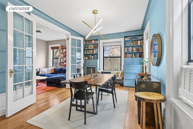 875 W 181st St Unit 6B, New York City, NY 10033 - dining area featuring french doors, light wood-type flooring, and a chandelier