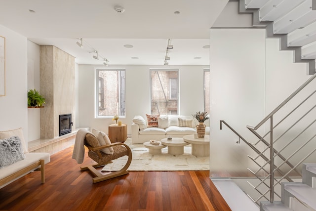 9 Minetta St, New York City, NY 10012 - living area featuring rail lighting, stairs, wood finished floors, and a fireplace