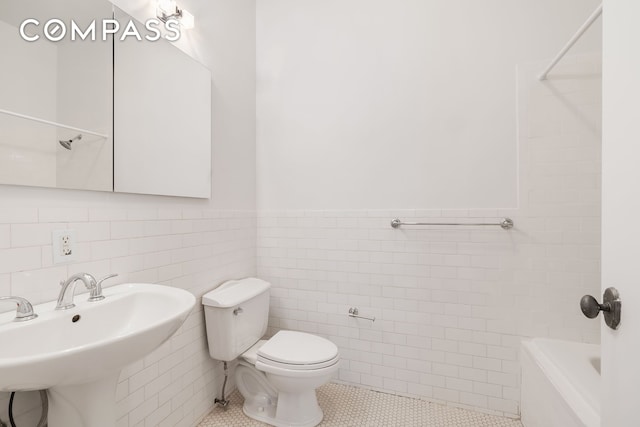 689 Myrtle Ave Unit 4E, New York City, NY 11205 - bathroom with tile walls, a wainscoted wall, and tile patterned flooring