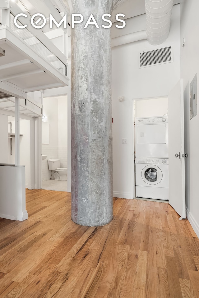 689 Myrtle Ave Unit 4E, New York City, NY 11205 - laundry area with stacked washer and clothes dryer and wood finished floors