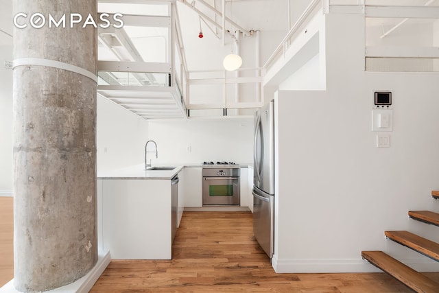 689 Myrtle Ave Unit 4E, New York City, NY 11205 - kitchen featuring appliances with stainless steel finishes, light wood-style flooring, light countertops, and white cabinets