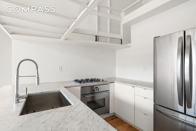 689 Myrtle Ave Unit 4E, New York City, NY 11205 - kitchen featuring stainless steel appliances, light stone counters, white cabinetry, light wood finished floors, and open shelves