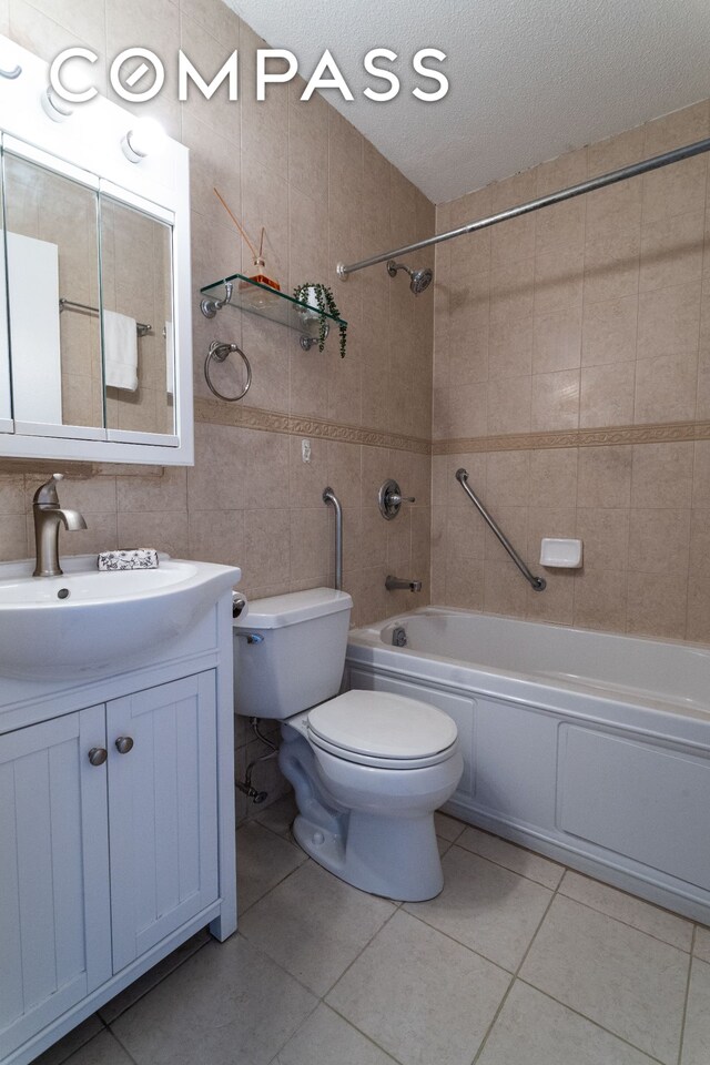 275 W 96th St Unit 12B, New York City, NY 10025 - bathroom with washtub / shower combination, toilet, vanity, tile walls, and a textured ceiling