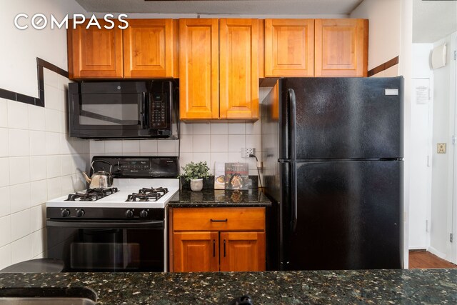 275 W 96th St Unit 12B, New York City, NY 10025 - kitchen with black appliances, dark stone counters, brown cabinets, and tasteful backsplash