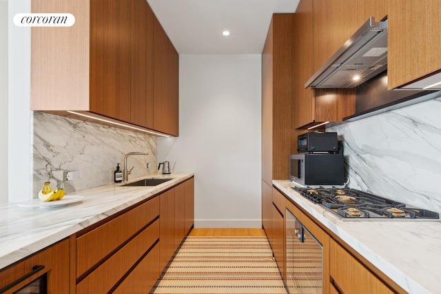 15 E 30th St Unit 22C, New York City, NY 10016 - kitchen featuring wall chimney range hood, tasteful backsplash, stainless steel appliances, and light stone countertops