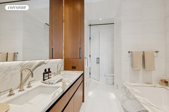 15 E 30th St Unit 22C, New York City, NY 10016 - bathroom with double vanity, a shower stall, a tub with marble appearance, tile walls, and marble finish flooring