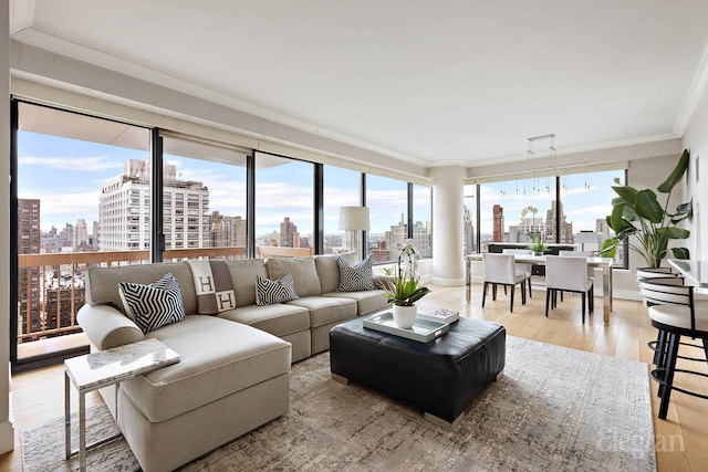 200 E 69th St Unit 28B, New York City, NY 10021 - living area with a view of skyline, ornamental molding, and light wood-style floors