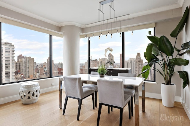 200 E 69th St Unit 28B, New York City, NY 10021 - dining space with a skyline view, ornamental molding, baseboards, and light wood-type flooring