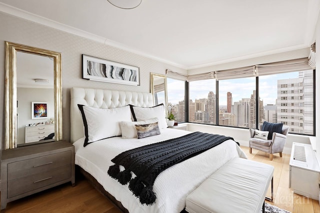 200 E 69th St Unit 28B, New York City, NY 10021 - bedroom featuring ornamental molding, wood finished floors, and a skyline view