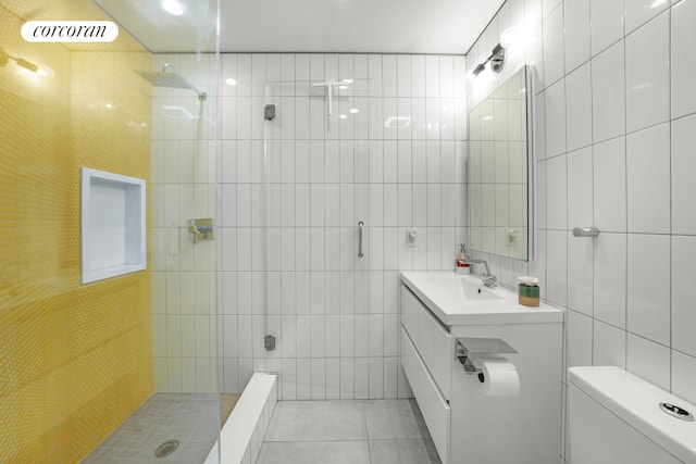 176 Johnson St Unit 2E, New York City, NY 11201 - bathroom featuring tile walls, a tile shower, vanity, and tile patterned flooring
