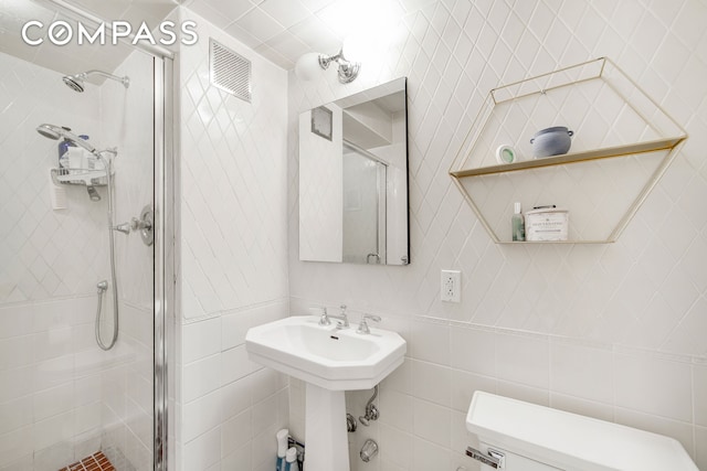 301 E 48th St Unit 5D, New York City, NY 10017 - full bathroom featuring a shower stall, toilet, tile walls, and a sink