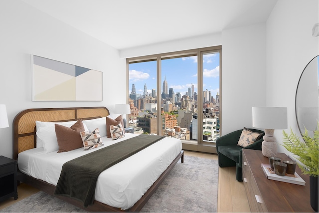 500 W 18th St Unit East15E, New York City, NY 10011 - bedroom with access to exterior, light wood-style floors, and a view of skyline
