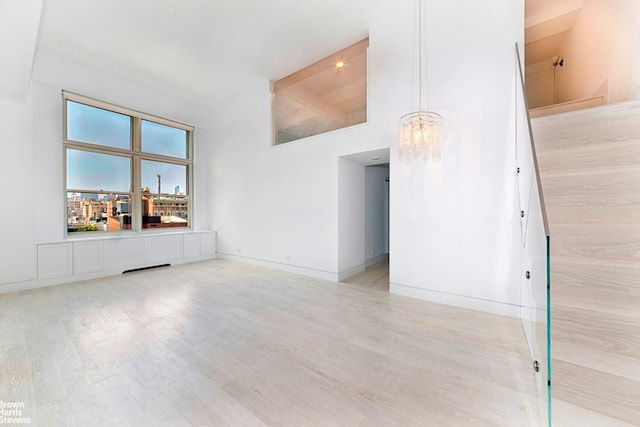 120 E 87th St Unit R14F, New York City, NY 10128 - unfurnished room with high vaulted ceiling, light wood finished floors, beamed ceiling, and a chandelier